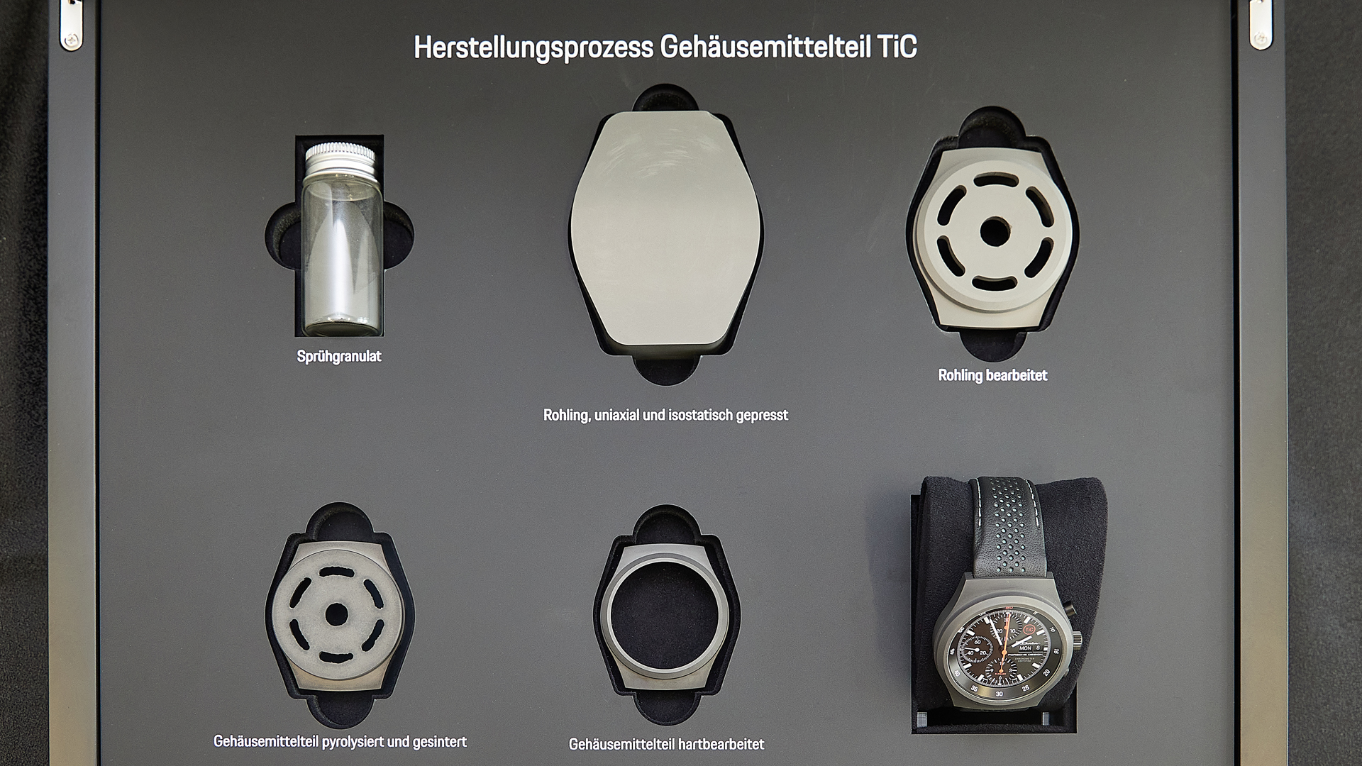 In einem Schaukasten zeigt Porsche Design die sechs Zustände von Titankarbid – vom Pulver bis zum fertigen Uhrengehäuse.
